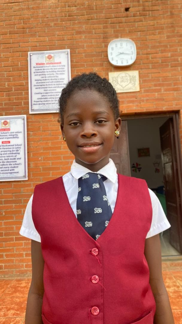 Kehinde Adeyemi, OVC Beneficiary smiling in school uniform