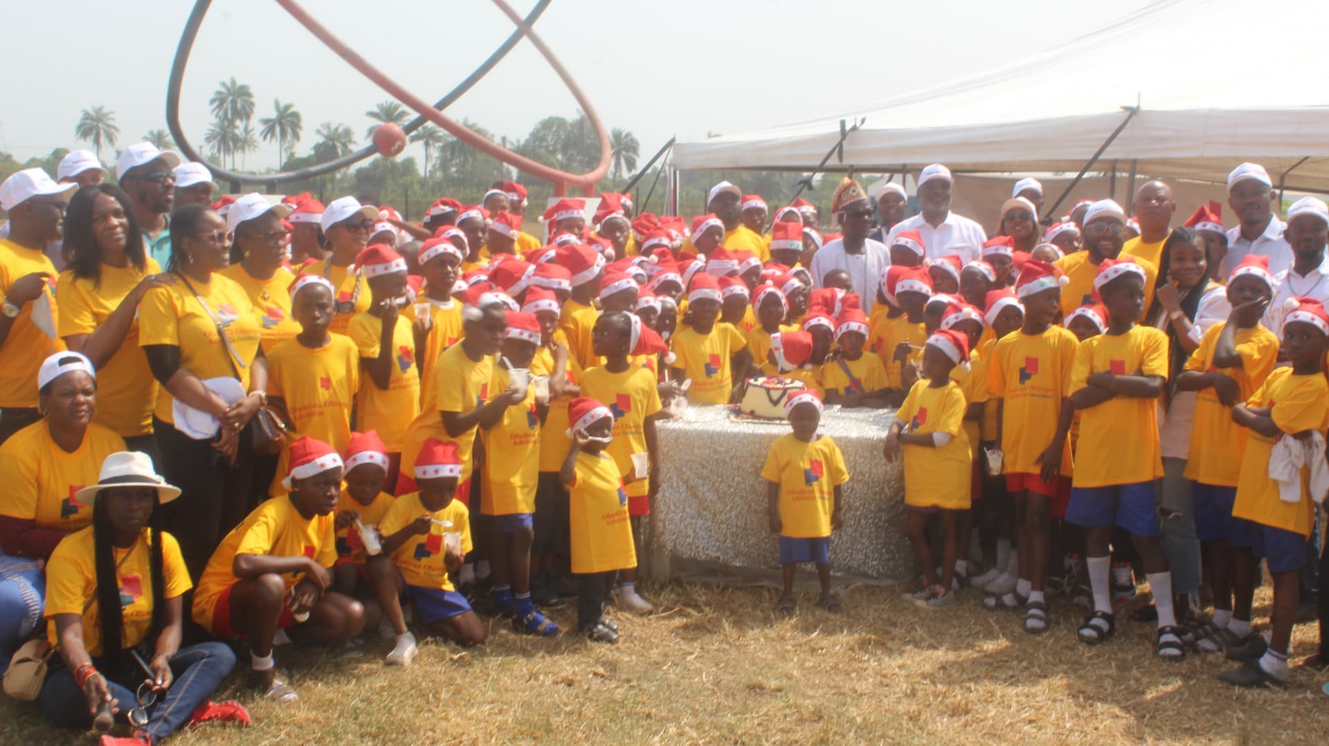 Crowd gathered around 10th anniversary celebration cake — OOA Foundation community